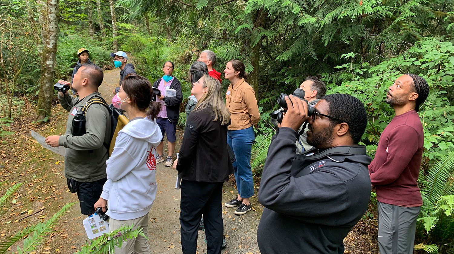 Rising Star Elementary staff looking and listening for birds in IslandWood