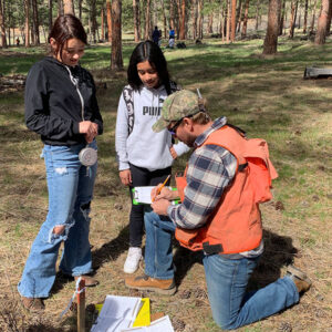Andy Townsend, Washington Department of Natural Resources, helps students collect data about the local forest.