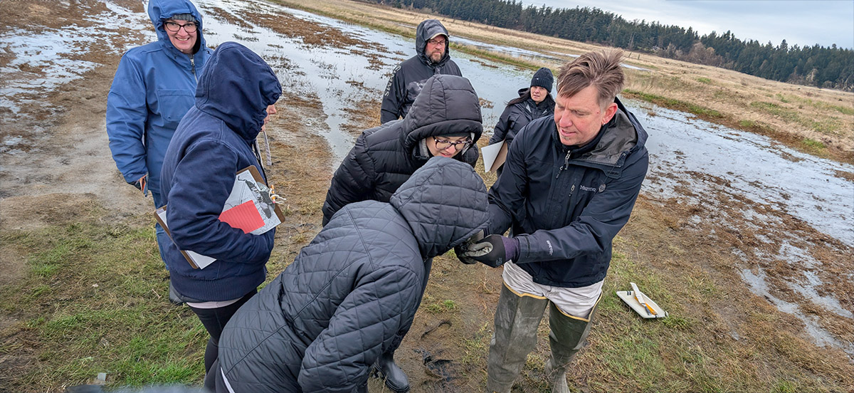 Dr. Jude Apple, Director of the Padilla Bay National Estuarine Research Reserve, invites K-12 teacher participants to compare observations (including the smell!) of two mud core samples to explore the "blue carbon" that wetlands store.